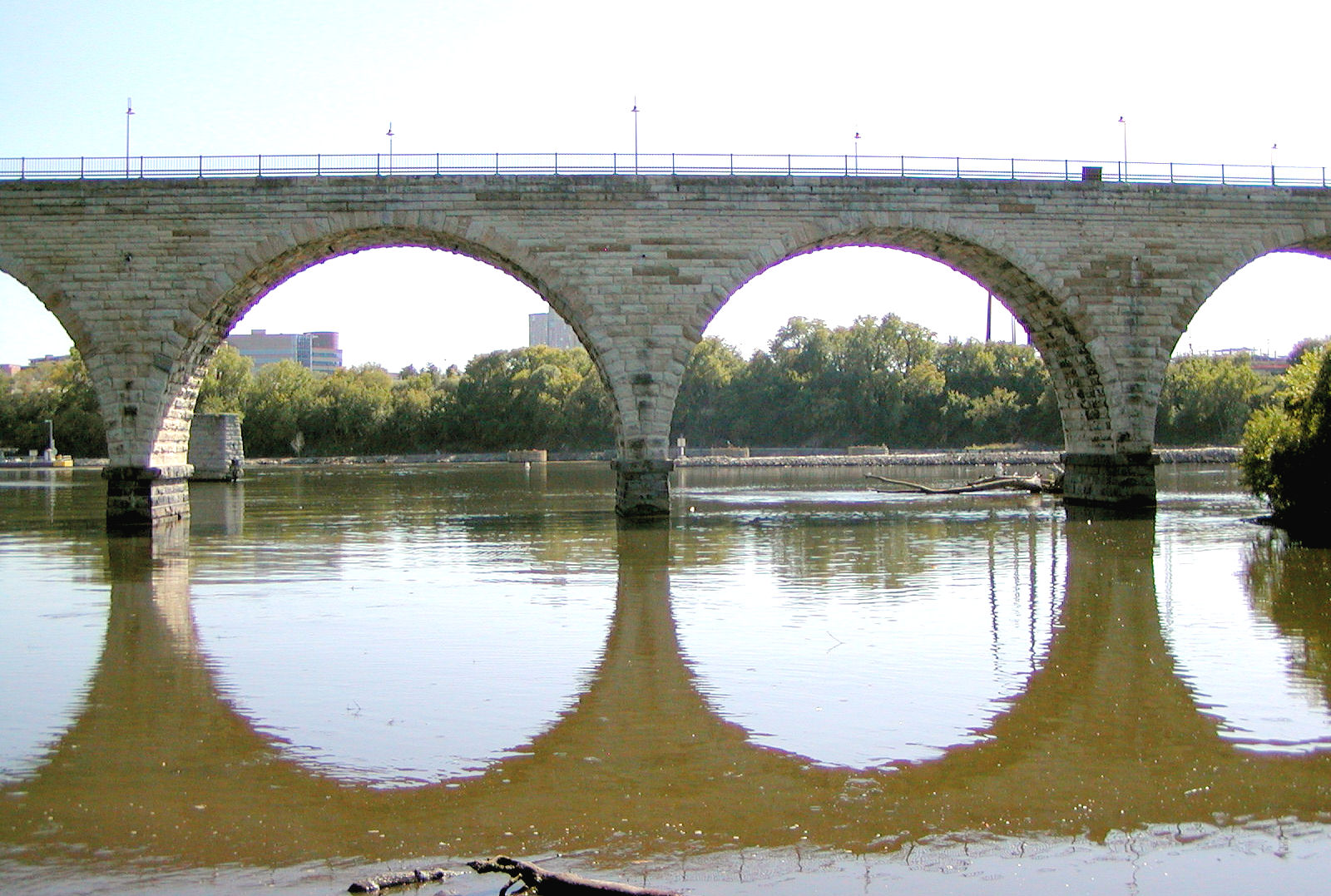The Stone Arch Bridge in Minneapolis, limestone arches reflected on the Mississippi