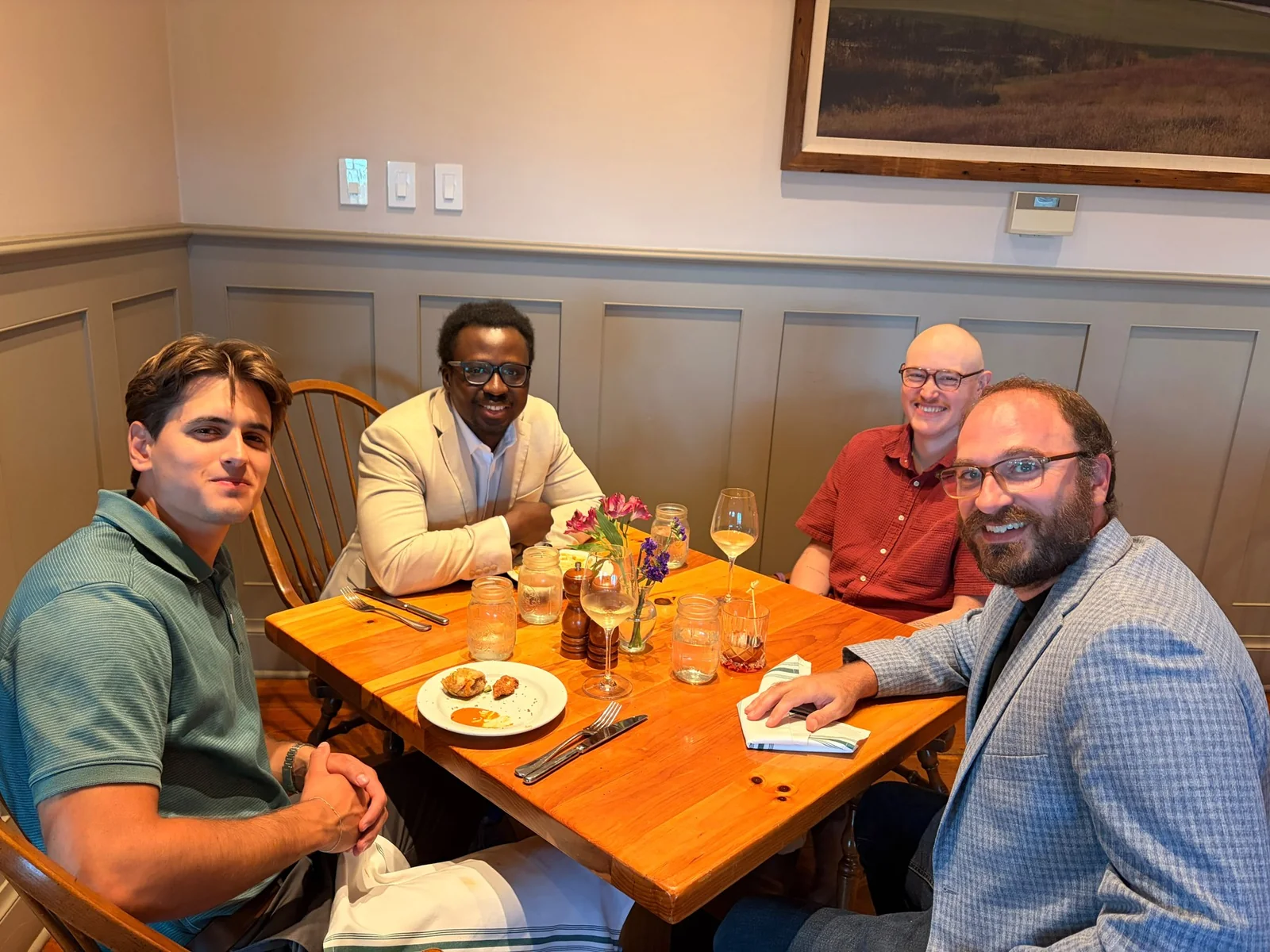 Four dinner guests seated together around a table at Windsong Farm